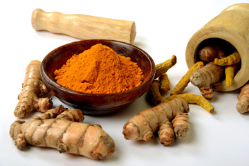 Organic healthy Turmeric powder in a bowl with Turmeric roots on white background