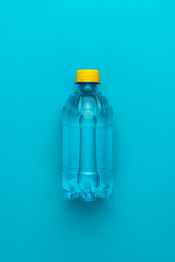 plastic water bottle with yellow cap on the blue background