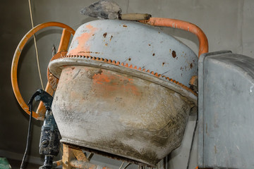 Concrete mixer and hammer drill at the construction site
