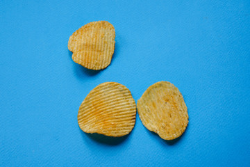 crispy potato chips on blue background. nachos chips