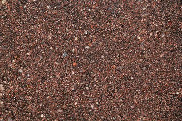 Texture of coarse sand with red stone chips