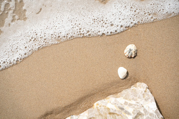 sea wave with bubbles on the sand beach
