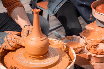 Master-class on clay modeling on a potter's wheel in a workshop on the street