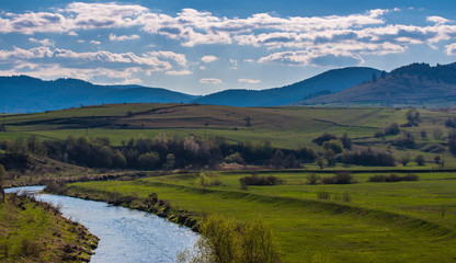 Fototapeta na wymiar Olt river in Transylvania, Romania, blue mountains at early spring, landscape image.