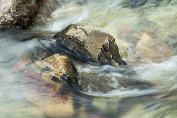 closeup of river with rocks on long exposure