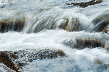 closeup of river with rocks on long exposure