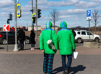 Two dressed people in clothing firms advertising products to people and using a megaphone to transmit information to people