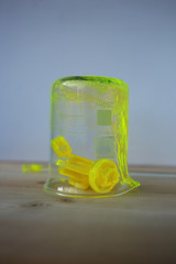 An upside-down chemical beaker with hardened pieces of fluorescent soap.