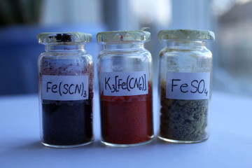 Analytical chemistry reagents: black iron thiocyanate, red potassium hexacyanoferrate, green ferrous sulfate.