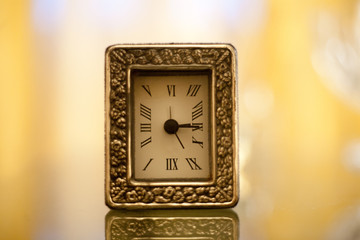 orologio vintage oro su un tavolo di vetro effetto bokeh