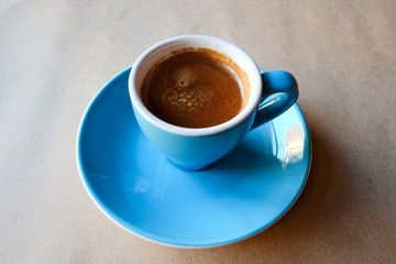 Cup of coffee on wooden table. Espresso shot with crema.