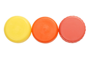 Three colorful plastic bottle caps isolated on white background