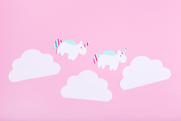 Paper unicorns and clouds on pink background. Minimalism concept