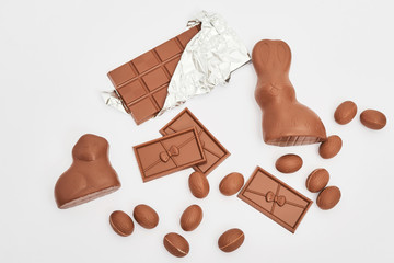 Delicious chocolate Easter bunny and eggs on white background top view copy space. Easter Greeting Card Template. Happy easter concept. Chocolate on white background. Chocolate Bars and Easter Sweets