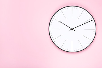Round clock on pink background
