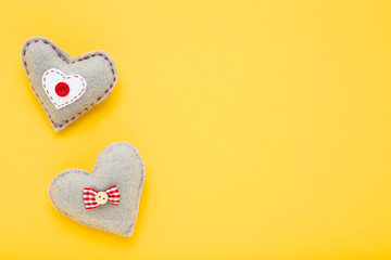 Grey fabric hearts on yellow background