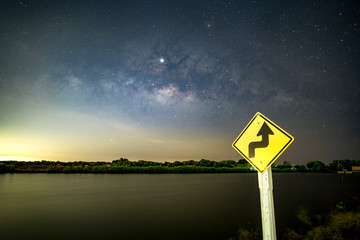 Signs, signs, beware of curves at night, behind the sign, with the Milky Way. © Ake