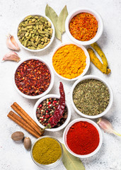 Spices, herbs and olive oil over white stone table.