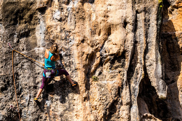 A girl climbs a rock.