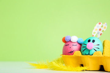 Cute easter eggs with yellow feathers on green background