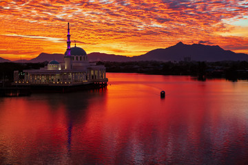 Scenic view of floating mosque on Sarawak river with colorful sunset clouds background. Waterfront...