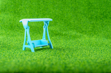 Blue Swings put on the green grass in the park or garden.