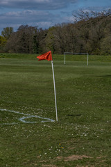 Obraz premium Football- Soccer match at the park, Football corner flag flapping in the wind. Parks/Outdoor