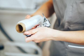 woman prepare instruments for permanent makeup to work use wrap tape for sterility, tools for tattoo ready to use