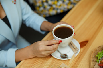 top view woman in blue jacket hold cup of coffee
