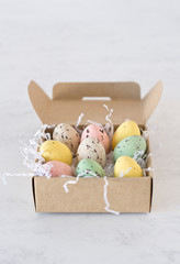 wooden paper box filled with mini chocolate easter eggs on white background