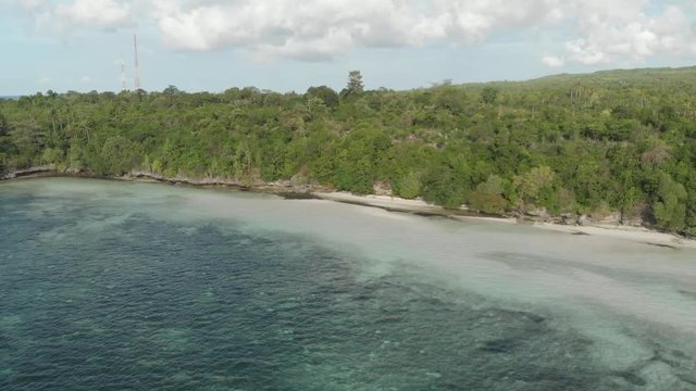 Aerial: Flying over tropical beach turquoise water coral reef , Tomia island Wakatobi National Park Indonesia Maldives Polynesia white sand beach. Native cinelike D-log color profile