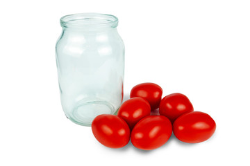 Fresh red tomatoes next to a glass jar on a white background. Preparation for conservation
