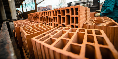 Clay bricks construction material loaded in the back of the delivery truck close up