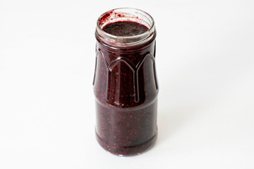 Glass jar with red jam on the table
