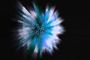 colored plastic drinking straws on black background, zoom blur effect