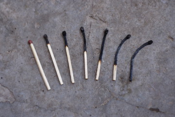 Different stages of  match burning on grey background