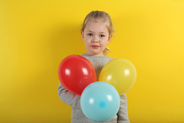 Fototapeta na wymiar Cute small girl holding balloon. Fun and happy childhood. Cheerful holiday.