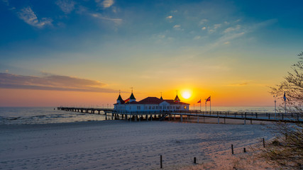 Fototapeta premium Strand mit Seebrücke bei Sonnenaufgang