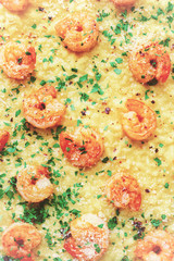 shrimps in saffron risotto decorated with parmesan, parsley and pink pepper. toned.