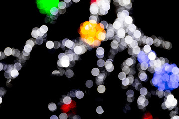 Unfocused abstract colourful bokeh with red, green, orange and blue lamp on black background. defocused and blurred many round light