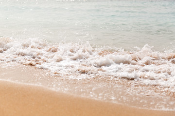 Powerful blue wave breaks along the shore. Close up