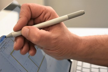 View of a male hand working with an optical pen on a screen