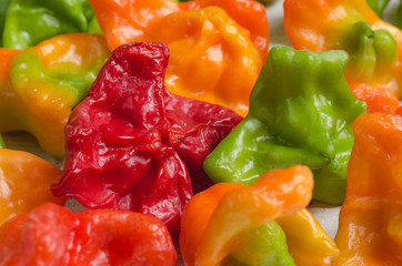 Colorful peppers of unusual shape on a white wooden table close-up