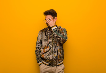 Young cool man embarrassed and laughing at the same time