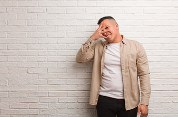 Young latin man embarrassed and laughing at the same time