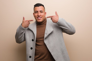 Young latin business man smiles, pointing mouth