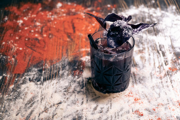 glass with dark cocktail with berries and basil leaf  © goami