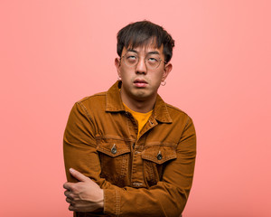Young chinese man wearing a jacket tired and bored