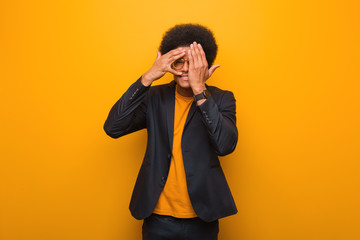 Young business african american man over an orange wall feels worried and scared