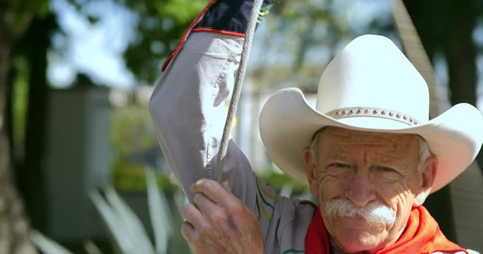 American cowboy throws a lasso rope at the ranch before rodeo, 4k